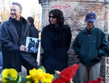 Original Doors members Ray Manzarek, left, and Robby Krieger, right, stand at Jim Morrison's grave, along with Ian Astbury of The Doors 21st Century.